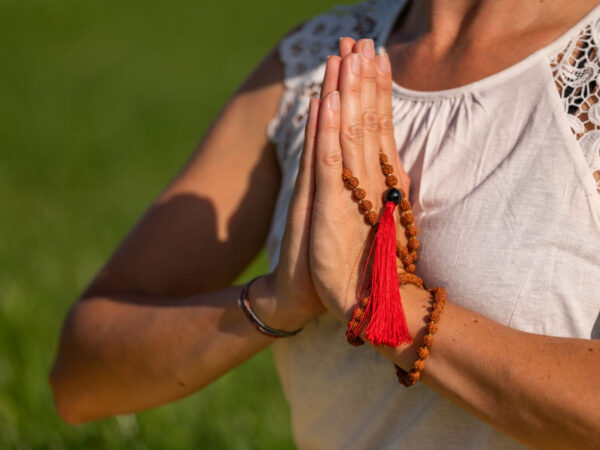 Yogalehrerin Sonja Vogt in Meditation: Die Hände sind vor dem Herzen gefaltet, während eine ruhige und friedvolle Praxis stattfindet.