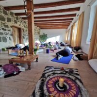 Yogis in einer Yin Position im Yogaraum des Yogaretreats